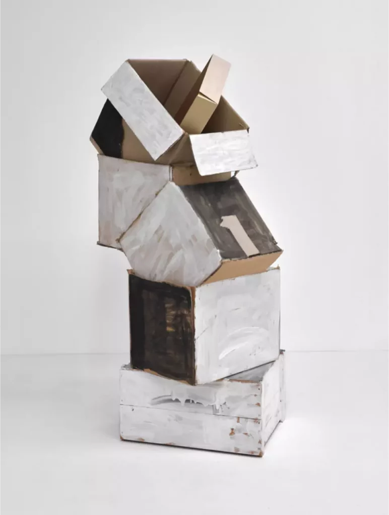 Oswald Oberhuber, Stapel, 1990, boîte en bois, boîtes en carton ondulé, boîte en carton, carton ondulé coloré, dispersion, crayon, 105 × 56.5 × 45 cm Sculpture de l'artiste autrichien Oswald Oberhuber formée d'un empilement de boites en carton peint en blanc, gris et noir collé sur une caisse bois peinte en blanc et en gris.