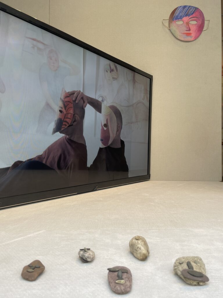 Broadcast of the performance There are Eyes (Prinz Gholam, There are Eyes, 2022, HD mp4 video with sound, 43 min 12 s) View of Prinz Gholam's exhibition There are Eyes, showing stone sculptures, a mask drawn with coloured pencils and a video extract from the performance There are Eyes.