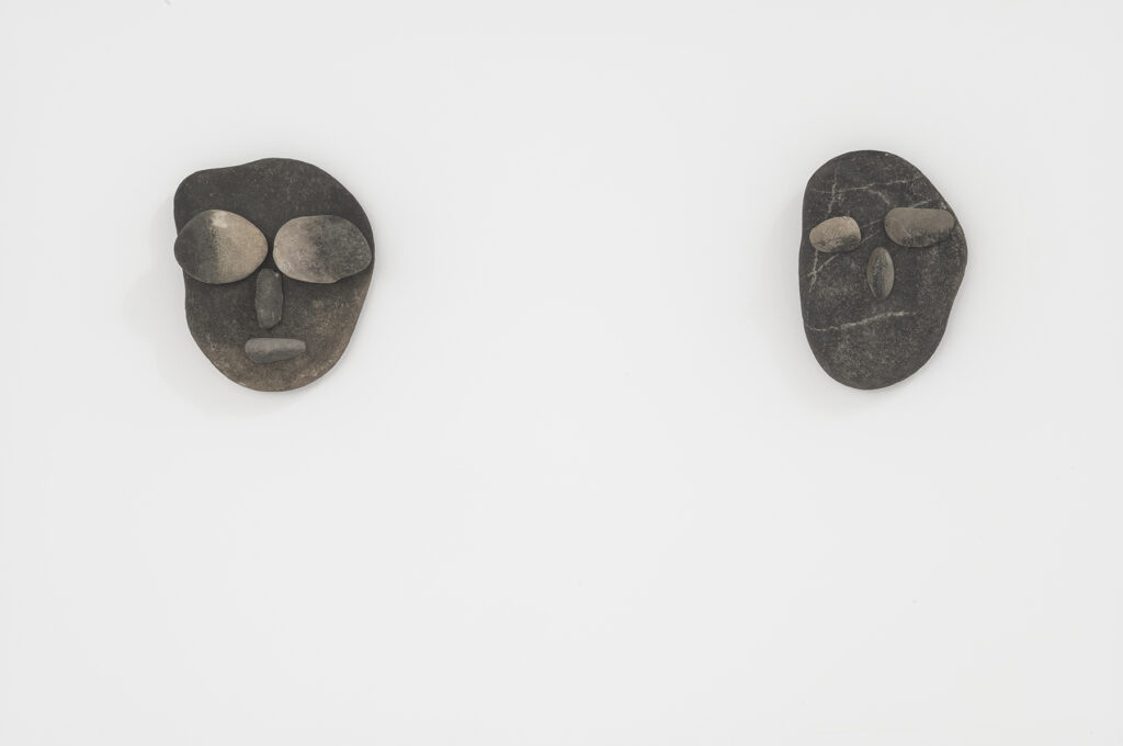 Sculptures en pierres collées représentant des visages réalisées par le duo d'artistes Prinz Gholam